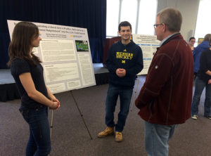 Students Lauren Shepard and Brandon Hopen discuss their project with Tim McKay, Arthur F. Thurnau Professor of Physics.