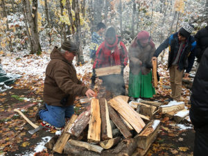 Students and faculty help build the fire that will heat rocks for the sweat lodge. 