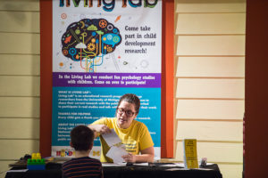 Merranda McLaughlin, lab manager, shows Dallin Loosli a photo. His answers give researchers insight into how young children think abstractly and use categories.