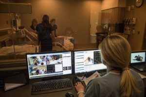 Clinical instructor Maureen Westfall at her control bank behind a one-way mirror in the Clinical Learning Center at the U-M School of Nursing. She operates Victoria wirelessly and students respond to the various medical conditions she presents. Credit: Michigan Photography