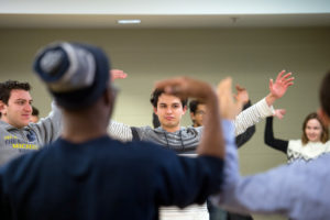 Shean Krolicki, center, Mohamad Bazzi, left, and William Royster, facing away from the camera, warm up before the session on public speaking. 