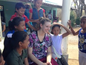 U-M Dearborn student Natasha Hampton relaxes with children in Honduras after giving fluoride treatments and helping them learn to brush. The Lincoln Park senior joined other UM-Dearborn students as part of a medical brigade building public health facilities. Photo by Marilee Benore