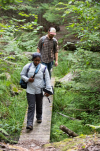 U-M wildlife ecologist Nyeema Harris and graduate student Corbin Kuntze heading into the forest at the University of Michigan Biological Station to install “camera traps” to capture wildlife images. The Biological Station is one of three Michigan sites in the study, which will yield hundreds of thousands of wildlife snapshots. Photos by Eric Bronson, Michigan Photography