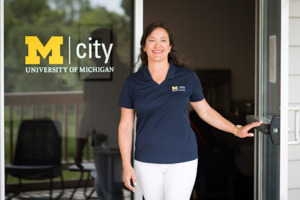 Carie Morton stands in the glass doorway of the M city office