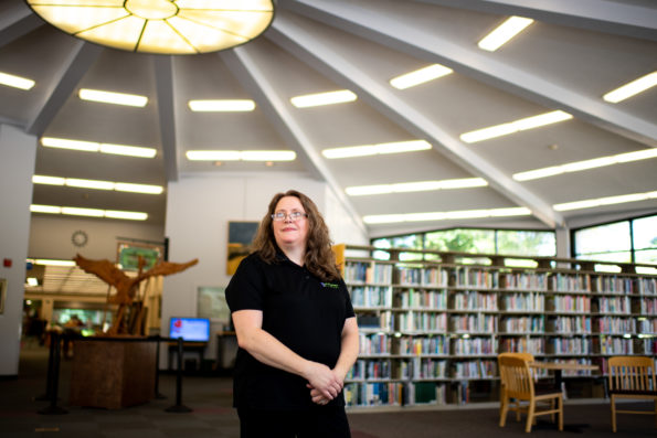 Laura Hollister stands amongst shelves of books at the Niles District Library.