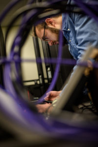 Traylor is seen concentrating through a jumble of wires and cables.