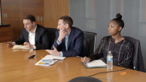 Students sit side by side in a conference room.