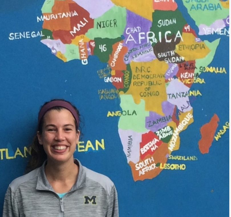 Boyle stands in front of a wall painted with the continent Africa.