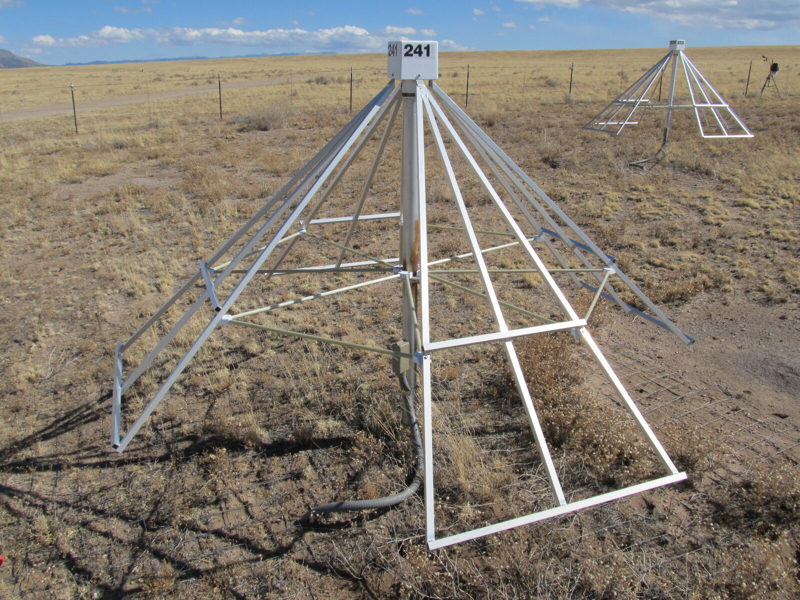 Cone shaped metal structure sitting on a barren, dusty landscape.